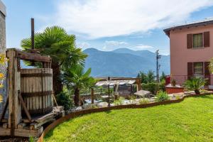 un jardin avec une clôture et une maison dans l'établissement Il Mallo Verde - Lake Como B&B, à Mandello del Lario