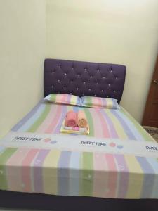a bed with two flip flops on top of it at Wafiy Homestay in Machang