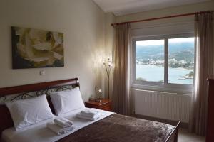 a bedroom with a bed and a large window at Aegean Dreams Villa Palio in Paleo Tsifliki +54 photos