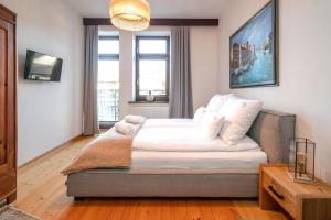 una camera da letto con un grande letto con lenzuola bianche di Aloj Zakopane by Loft Affair a Zakopane