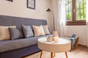 ein Wohnzimmer mit einem blauen Sofa und einem Tisch in der Unterkunft Apartamento Clover in L'Escala