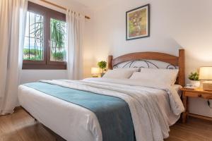 a bedroom with a large bed and a window at Apartamento Clover in L'Escala