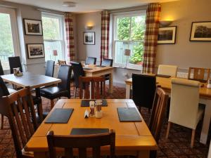 un restaurante con mesas y sillas de madera y ventanas en The Board Inn - Lealholm en Whitby