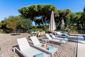 a group of lounge chairs and umbrellas at a resort at Villa Sea, Sun and Golf in Vilamoura in Quarteira