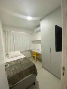 una camera da letto con un letto, una scrivania e una televisione di Edifício Promenade II Apt 303- Mandi Hospitalidade a Maceió
