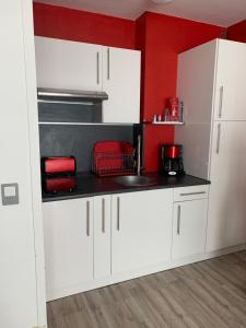 a kitchen with white cabinets and a sink at Studio La Mongie in La Mongie +6 photos