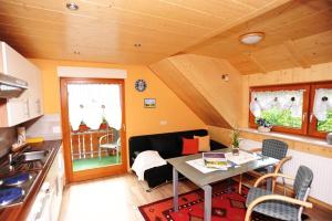 a kitchen and a living room with a table in a room at Pension Haus Rose in Oberharmersbach