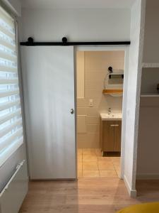 eine Tür, die in ein Bad mit einem Waschbecken führt in der Unterkunft Appart avec chambre lumineux et chaleureux in Le Boulou