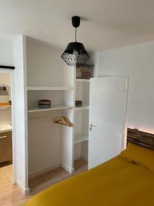 ein Schlafzimmer mit einem gelben Bett und einer schwarzen Lampe in der Unterkunft Appart avec chambre lumineux et chaleureux in Le Boulou