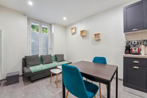 a living room with a table and a couch at Appartement budget avec parking au centre-ville in Charleville-Mézières