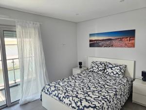 een witte slaapkamer met een bed en een raam bij Apartment Dona Vitória - Monte Gordo Beach in Monte Gordo
