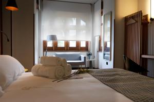 a bedroom with a bed with a chair and a couch at Hotel El Rosal de Cudillero in Cudillero