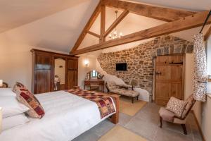 a bedroom with a large bed and a stone wall at 18th century renovated barn in beautiful Devon countryside in Broadwoodwidger