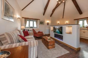ein Wohnzimmer mit Sofa und Fernseher in der Unterkunft 18th century renovated barn in beautiful Devon countryside in Broadwoodwidger + 25 Fotos