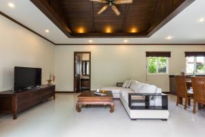sala de estar con sofá y TV en Thai-Balinese Boutique Villa Alex in Rawai, 3BR, Private Pool en Rawai Beach