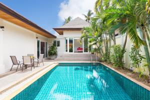 una piscina frente a una casa con villa en Thai-Balinese Boutique Villa Alex in Rawai, 3BR, Private Pool en Rawai Beach
