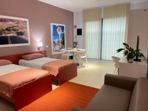 um quarto de hotel com duas camas e uma mesa em Motel Vespucci em Guasticce