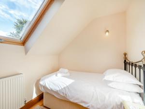 a bedroom with a bed with white sheets and a window at Barley Cottage- Uk45598 in Verwick