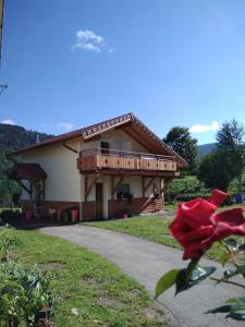 a house with a balcony and a red rose at Haut pré de ces Dames in Cornimont