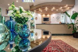 una muestra de jarrones azules y flores en una mesa en Hotel Excelsior en Bibione