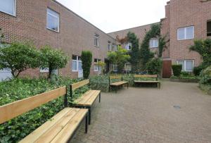 un patio con bancos frente a un edificio de ladrillo en Budget Flats Leuven - Budget Studio Twin, en Lovaina