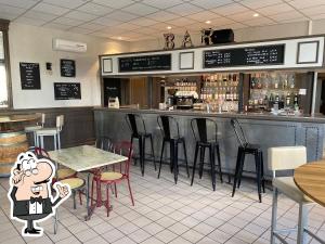ein Restaurant mit einer Bar mit Stühlen und Tischen in der Unterkunft La Cigogne in Panissières