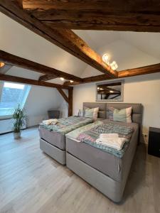 2 Betten in einem Zimmer mit Holzdecken in der Unterkunft Ferienwohnungen Yanev in Oberkotzau