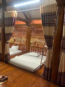 a room with two beds in a room with windows at Son Thuy Homestay in Ha Giang