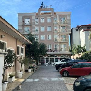 um hotel com carros estacionados num parque de estacionamento em KEIT Hotel em Tirana
