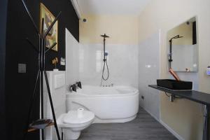 y baño con bañera blanca y aseo. en Baignoire Cosy Centre Narbonne, en Narbona