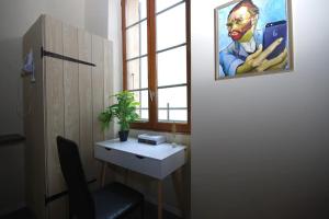 Habitación con escritorio y una pintura en la pared. en Baignoire Cosy Centre Narbonne, en Narbona