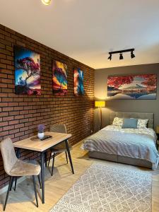 a bedroom with a bed and a brick wall at Apartamenty 1-maja 94 in Katowice