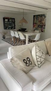 een witte bank in een woonkamer met een tafel bij Charming Cottage Within Walking To Beach in Holeby