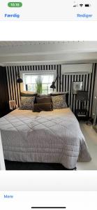 a bedroom with a large bed with striped walls at Bondehus in Holeby