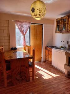 cocina con mesa de madera en una habitación en Cabaña valle de elqui horcon Encantó del pimiento en Horcon