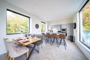 a kitchen and dining room with a table and chairs at Luxurious 4-Bedroom Penthouse: 15 Mins to City Centre, Secure Parking in Leeds