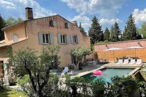 una casa y una piscina con un frisbee rosa en Mas de Clary - propriété de caractère avec PISCINE, en Roquemaure