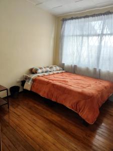 a bed sitting in a bedroom with a window at Hakuna Matata Home in Cuenca