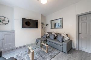 a living room with a couch and a tv at Guestz 2 Bedroom House Near Anfield in Liverpool