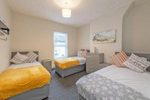 a bedroom with two beds and a window at Guestz 2 Bedroom House Near Anfield in Liverpool