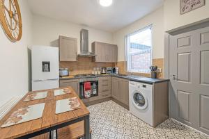 a kitchen with a refrigerator and a washing machine at Guestz 2 Bedroom House Near Anfield in Liverpool
