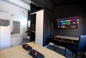 a bathroom with a bed and a tv on the wall at Charmant Studio Baignoire in Narbonne