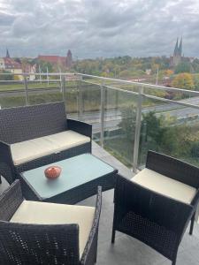 a balcony with chairs and a table with a bowl on it at Apartament olsztyn 15 Dywizji 6C 34 in Olsztyn