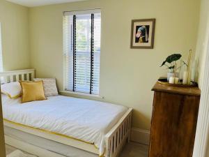 a small bed in a room with a window at Rayners Farm Lodge in Mattishall
