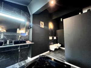 a bathroom with black walls and a sink and toilets at Moderne Jacuzzi Terrasse in Narbonne
