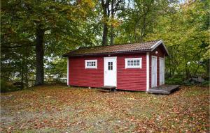 a small red shed sitting on top of a pile of leaves at Pet Friendly Home In Tormestorp With Kitchen in Tormestorp