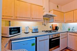 a kitchen with a microwave and a stove top oven at Gorgeous central London 2-bed flat in London