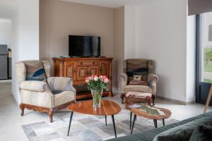 uma sala de estar com duas cadeiras e uma televisão em L'Eperonnette, cozy house with swimming pool, surrounded by vineyard, near St Emilion em Vérac