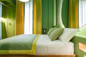 Schlafzimmer mit einem Bett mit grünen und gelben Wänden in der Unterkunft Le Texture Premium Rooms Duomo-Cordusio in Mailand