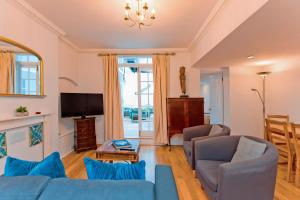 a living room with a blue couch and a tv at Gorgeous central London 2-bed flat in London